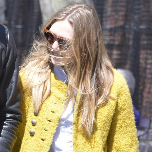 Elizabeth Olsen wearing a yellow coat over a white top