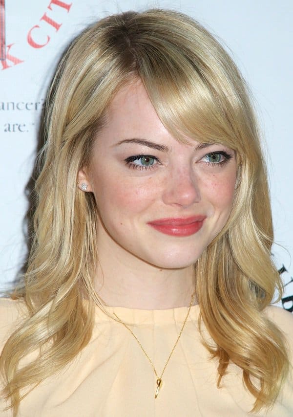 Emma Stone styled her formal pastel orange blouse with a simple necklace