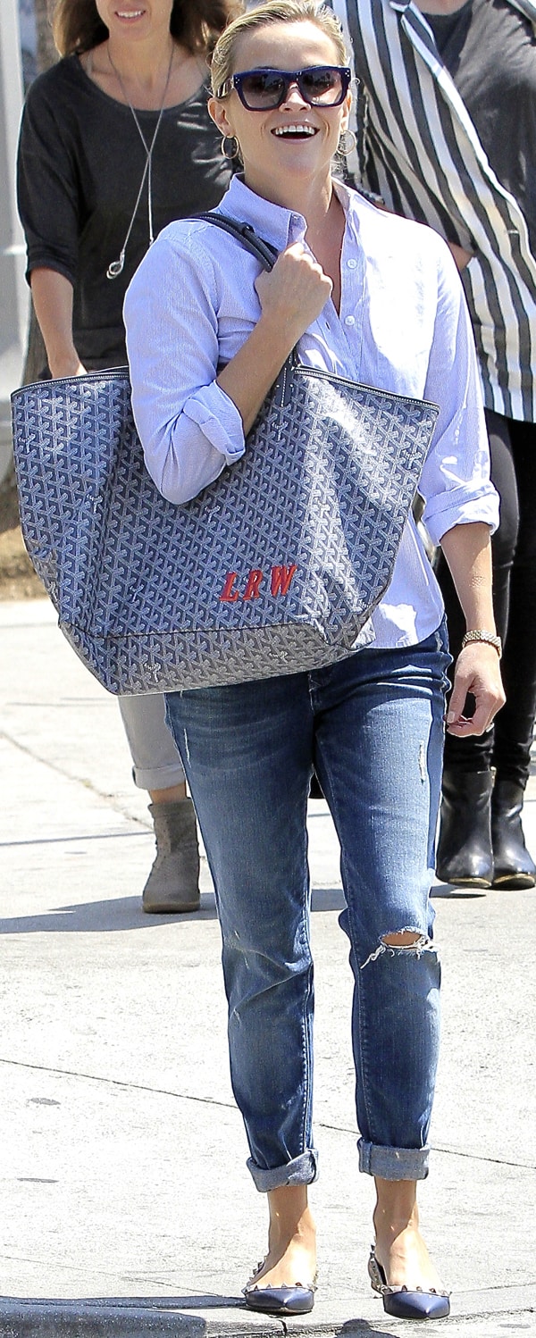 Reese Witherspoon wearing blue sunnies and a casual pinstriped button-down top