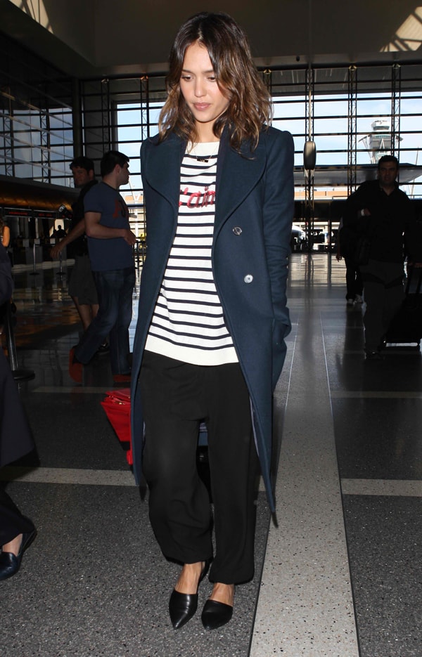 Jessica Alba in baggy top, trousers, and an oversized coat at the Los Angeles International Airport in California on February 25, 2014