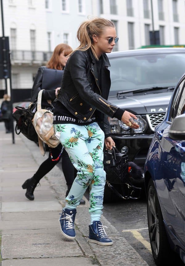 Cara Delevingne wearing tropical pineapple pants with a leather jacket
