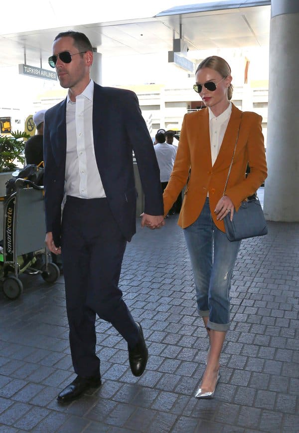 Kate Bosworth wearing three quarter length jeans, brown jacket and silver high heels, leaves Los Angeles International Airport (LAX) holding hands with husband Michael Polish in California on May 14, 2014