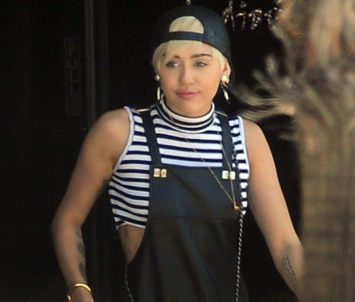 Miley Cyrus wears a 90s-inspired striped cropped top while furniture shopping