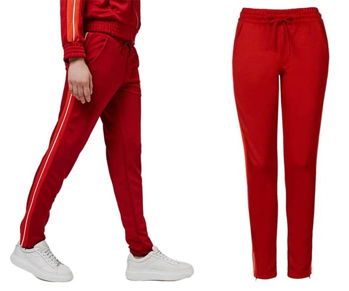 Orange-and-white racer stripes down the sides rev up the vintage athletic styling of red track pants in a soft knit with a stretchy drawstring waistband and hidden zips at the ankle