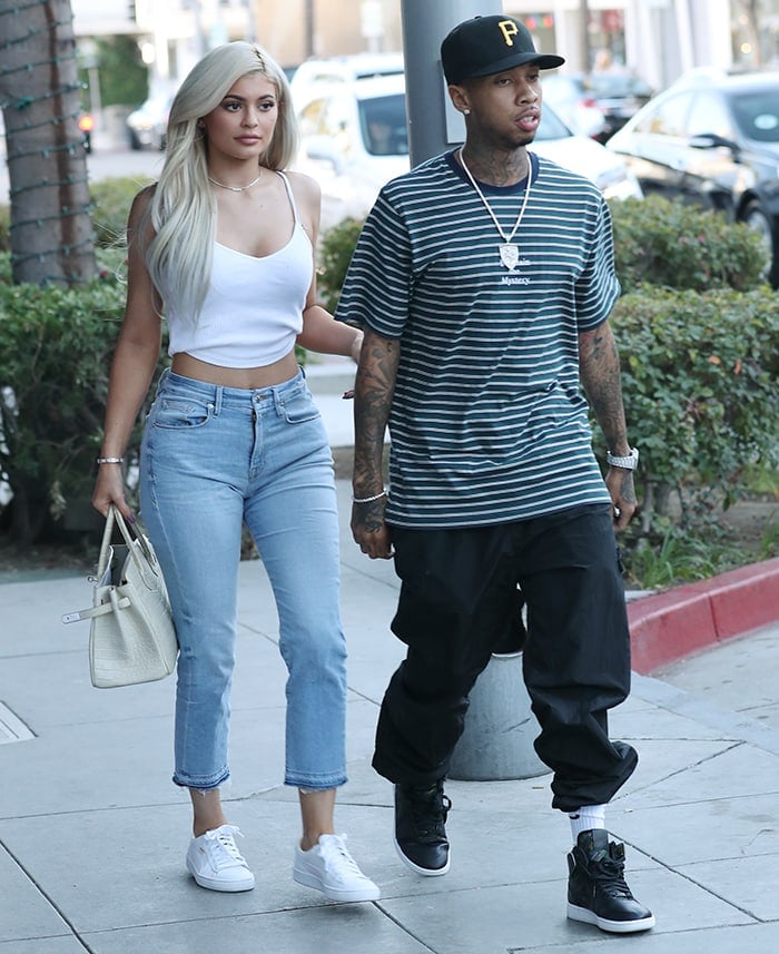 Kylie Jenner in a white crop tank top and raw hem crop jeans